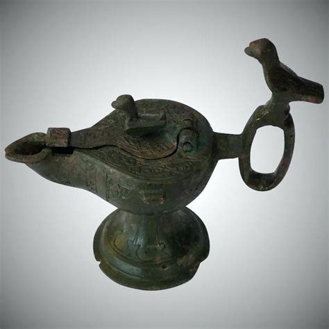 A durable bronze oil lamp with one noozle, reliefs of a fountain scene and handle with the form of a shell. bronze oil lamp antique medieval bronze oil lamp c ancient ...