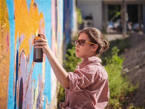 Beautiful Young Girl Making A Colorful Graffiti With Aerosol Spray On