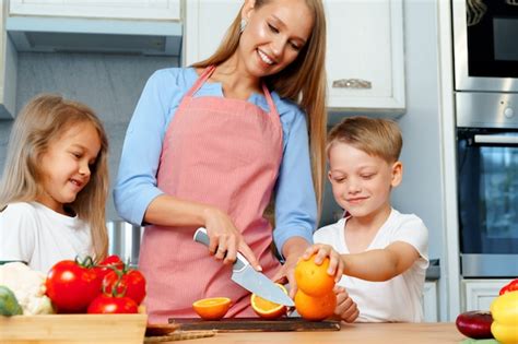 Madre Cocinando Con Sus Hijos En La Cocina Foto Premium