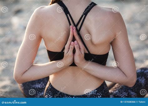 Unrecognizable Back Of Woman With Hand Behind Practicing Yoga At Sand