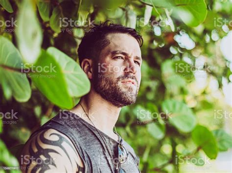 Tattooed Handsome Guy By Tropical Foliage In Cool Candid Portrait Stock
