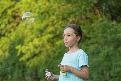 Happy Girl Blowing Bubble Outdoors Stock Photo Dissolve
