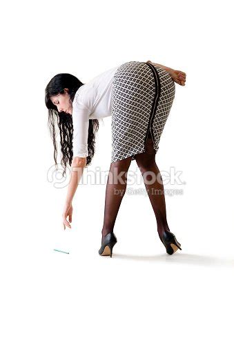 Young Beautiful Business Woman Bending Down To Pick Up Pencil Stock