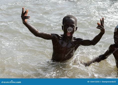 Unidentified Local Boys Swim In Water During A High Tide Editorial