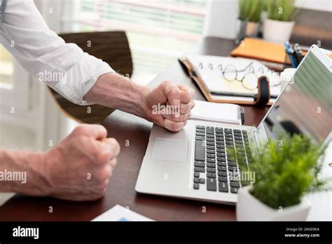 Angry Businessman Hitting His Desk With His Clenched Fists Stock Photo