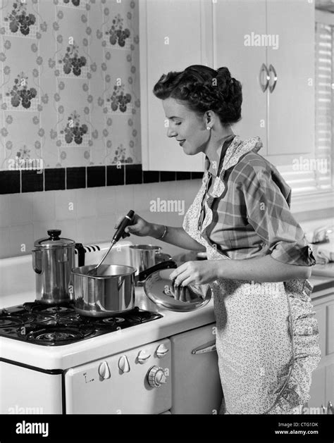 1950er Jahre Hausfrau In SchÜrze RÜhren Essen Im Topf Auf Herd
