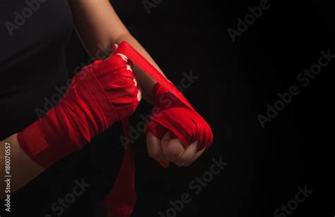 Female Boxer Is Wrapping Hands With Red Wrap Black Background With