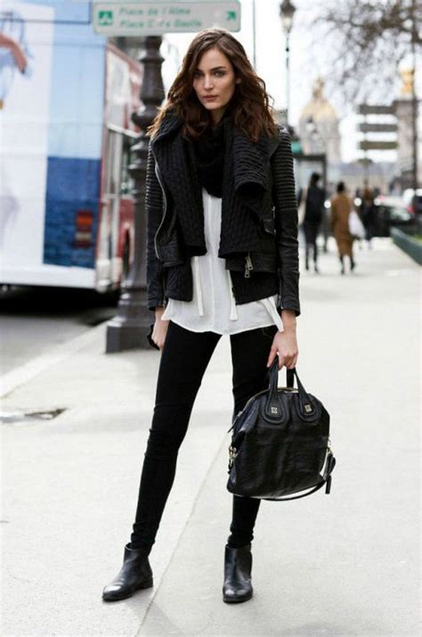 brunette woman with long hair black leather jacket skinny black pants white shirt and black