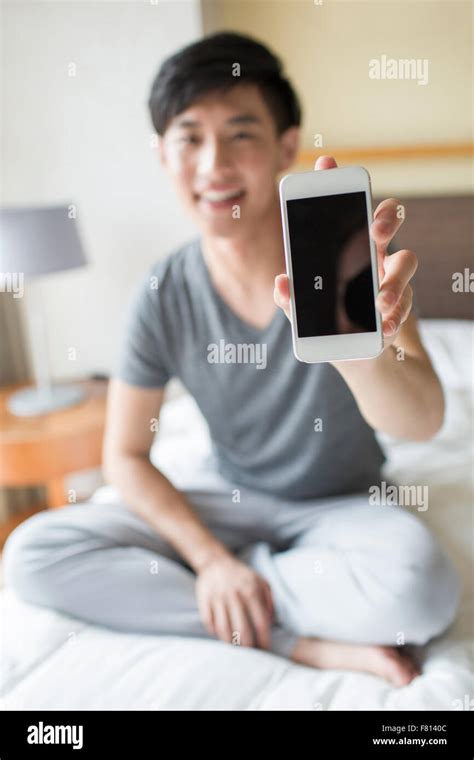 Young Man Showing Smart Phone On Bed Stock Photo Alamy