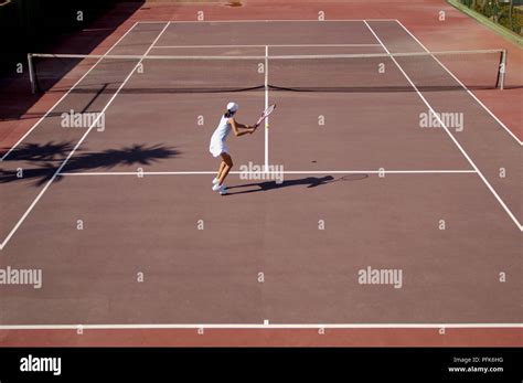Female Tennis Player Practising Forehand Stroke On Tennis Court Stock