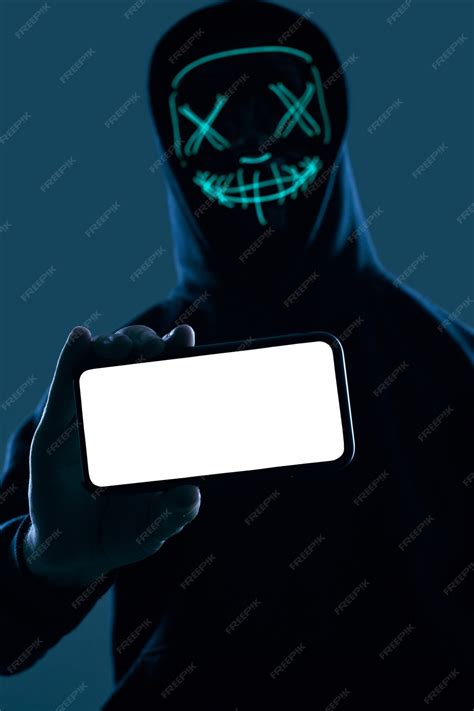 Premium Photo Anonymous Man In A Black Hoodie And Neon Mask Hacking