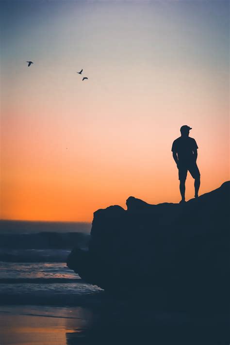 Man Standing On Rock Near On Seashore Photo Free Person Image On Unsplash