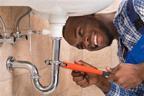 Happy Male Plumber Repairing Sink In Bathroom Stock Photo By
