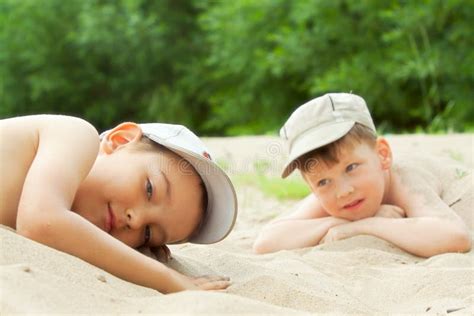 Two Boys Lying Down On The Sea Beach Stock Photo Image Of Outdoors