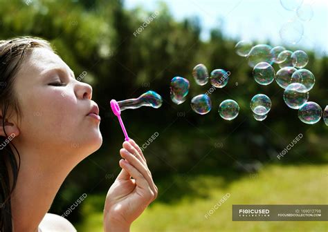 Girl Blowing Bubbles Outdoors Focus On Foreground Sunlight Nature