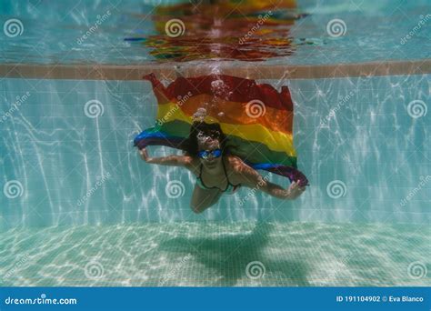 Young Woman In A Pool Holding Rainbow Gay Flag Underwaterlgbtq Concept