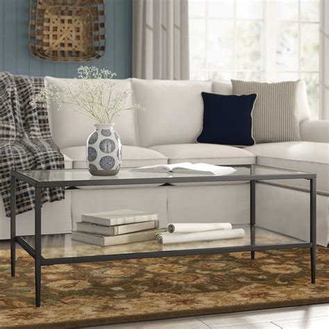 The circular tempered glass tabletop lets the architectural base shine through, and is mirrored by the open bottom shelf. Harlan Double Shelf Coffee Table | Glass top coffee table ...
