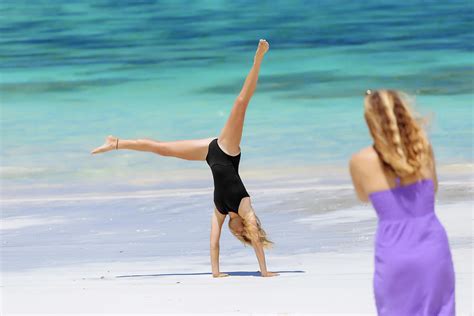 woman doing handstand on beach kuta photograph by konstantin trubavin