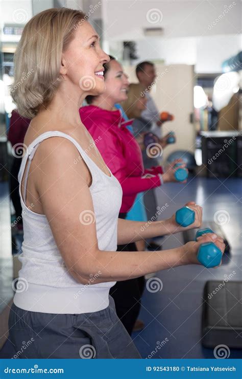 Mature Woman Doing Exercises With Dumbbells In The Gym Stock Photo