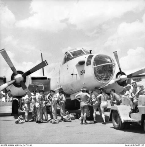 Australian And American Air Crew And Ground Crew Around The Nose Of A