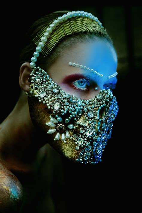 A Woman With Blue And Gold Make Up Wearing A Face Covered In Jewels