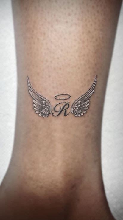 An Angel Wing Tattoo On The Back Of A Womans Neck Which Reads R