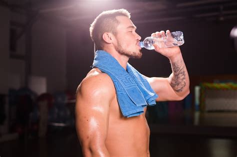 Premium Photo Young Bodybuilder In The Gym Drinking A Bottle Water