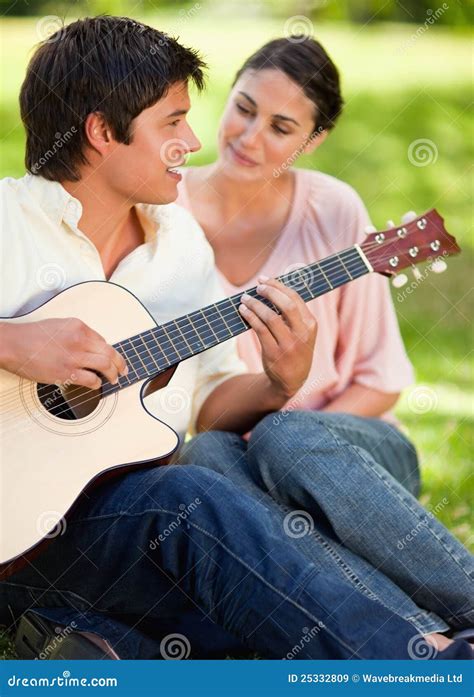 man smiling while playing the guitar while he is being watched b stock image image of leisure