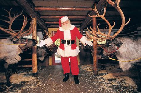 north pole santa feeding the reindeer christmas travel in search of santa claus tripatini