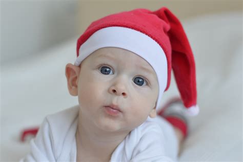 Baby Wearing Red Christmas Hat On White Textile · Free Stock Photo
