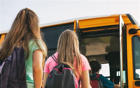 School Bus Girls With Backpacks Boarding Bus Del Colaborador De Stocksy Sean Locke Stocksy