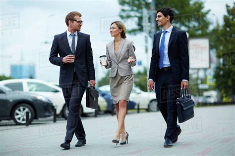 Young Business People Walking Together Along The Street Stock Photo