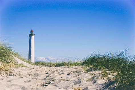Picalls.com | Lighthouse on the beach by Unsplash.