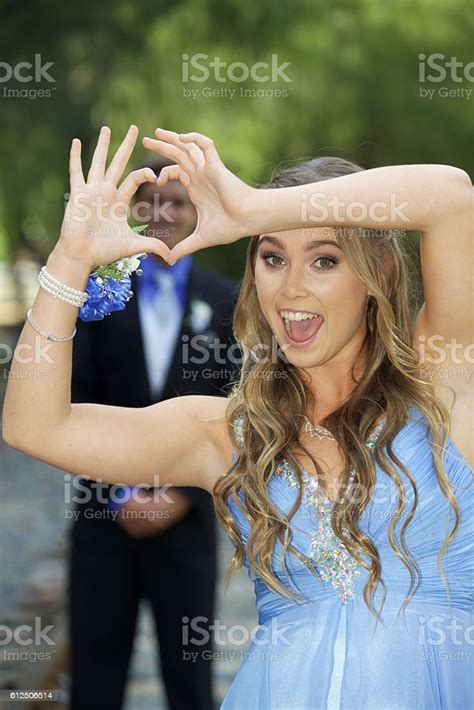 Cute Prom Couple Girl Framing Her Date With Heart Hands Stock Photo