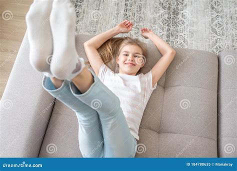Preteen Girl Lying On Couch With Her Feet Raising Up High Stock Image