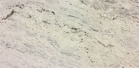 Cotton white granite has a primarily white background with gray and black accents. Daltile | Stone
