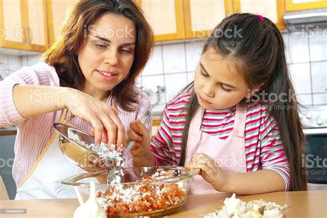 Mother And Daughter Prepare Meat For Lunch Stock Photo Download Image