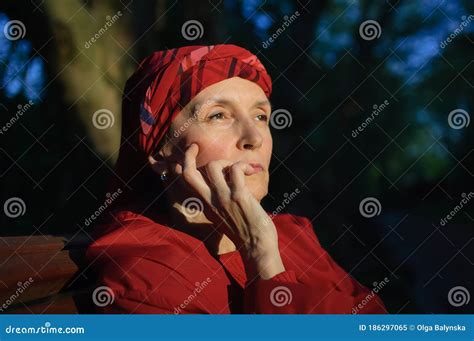 Retrato Femenino De Una Mujer Madura Vestida De Rojo Y Sentada En El