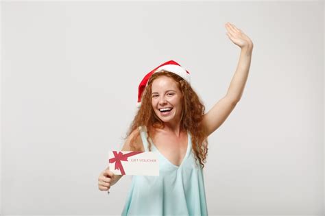 Free Photo Cheerful Young Redhead Santa Girl In Light Clothes Holding T Voucher
