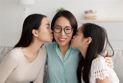Premium Photo Cheerful Mature Asian Woman In Glasses Being Kissed By