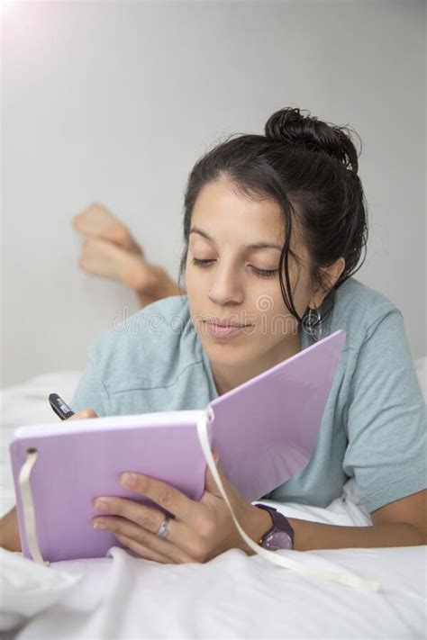 Caucasian Woman Wearing Only A T Shirt Writing In Her Notebook On The