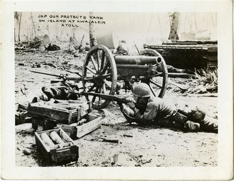A Us Soldier Takes Cover Behind A Japanese Artillery Gun And Ammunition