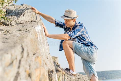 Male Hiker Climbing Up Mountain Cliff During Hiis Travel Stock Image