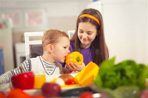 Boy And Girl Preparing And Eating Healthy Meal At Home Stock Photo