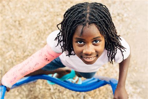 Smiling Black Girl Climbing A Ladder At A Playground By Stocksy Contributor Gabi Bucataru