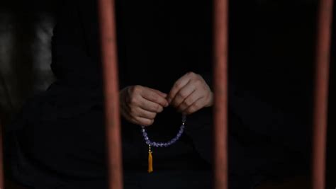 Close Up Hand Of Prisoner Muslim Woman Praying To God From Jail Stock