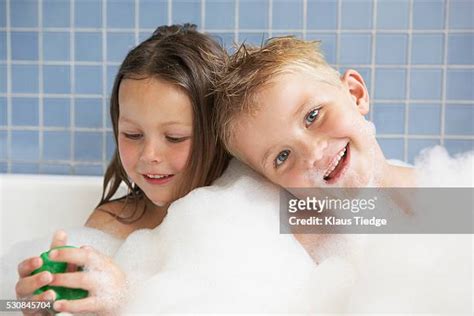 Brother And Sister Playing In Bath Tub Photos And Premium High Res