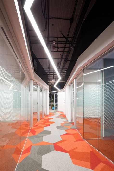 An Orange And Grey Carpeted Hallway With Glass Partitions On Both Sides