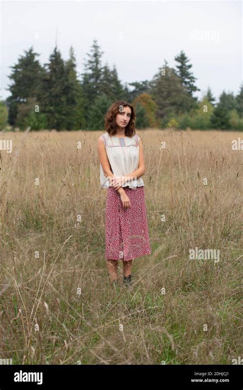 Portrait Of Seventeen Year Old Girl Standing In Field Of Tall Grasses