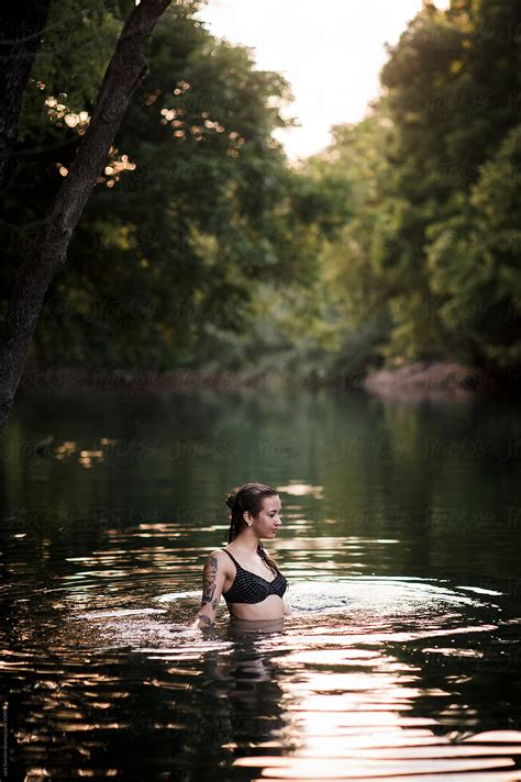 Young Woman Swimming In Creek By Jack Sorokin